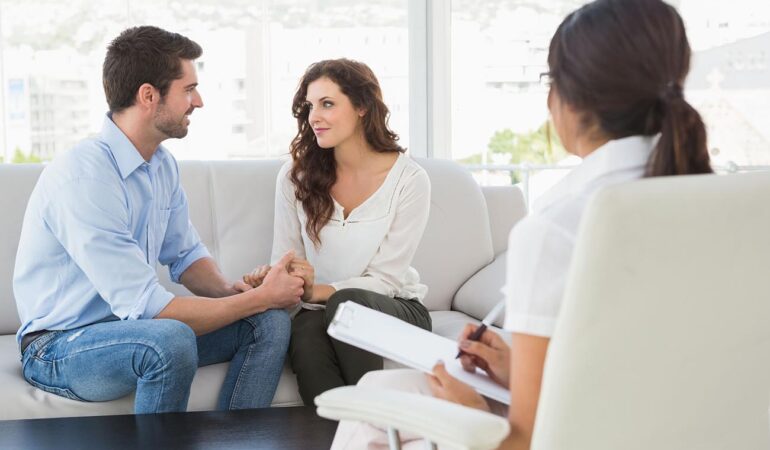 46208401 - reconciled couple smiling at each other in the therapist office